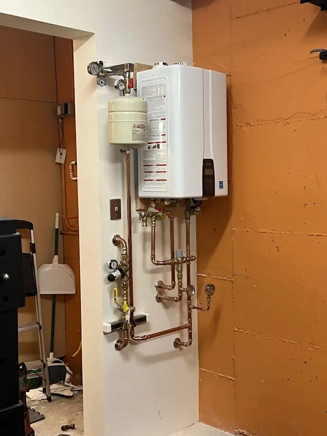 Plumbing technician inspecting water heater connections in El Dorado Springs